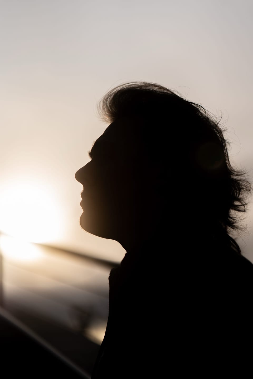Backlit profile silhouette of a woman in warm light