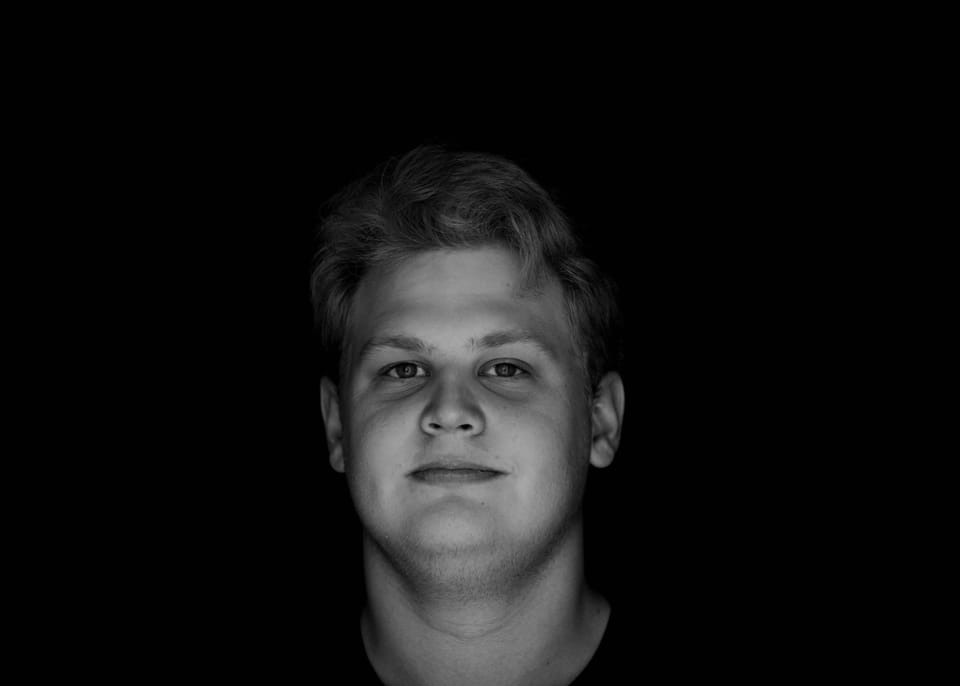 Black-and-white low-key portrait of a young man