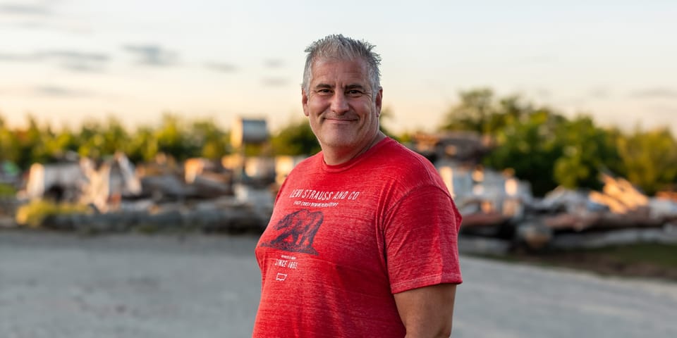 Man in a red T-shirt smiling at sunset