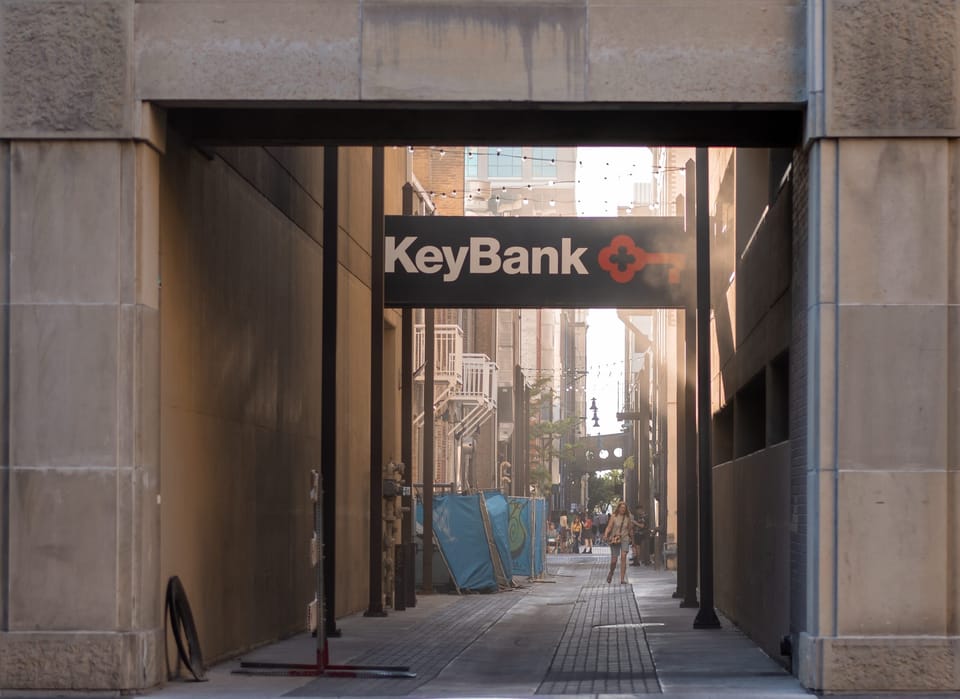 Covered city alley opening onto a street lined with signs
