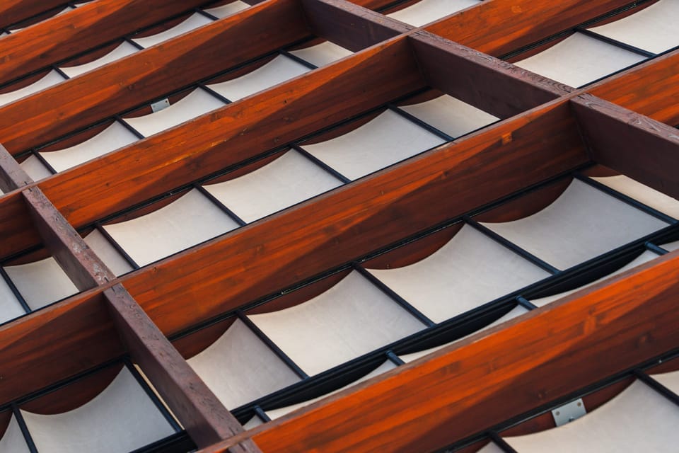 Abstract of rust-red architectural louvers against white panels