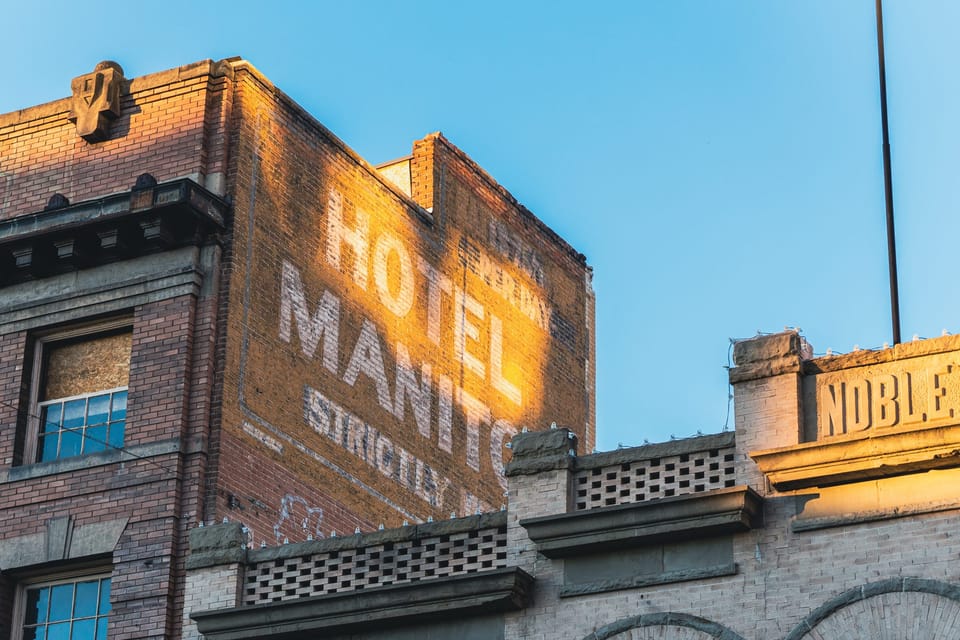 Vintage painted motel sign on a brick wall at golden hour