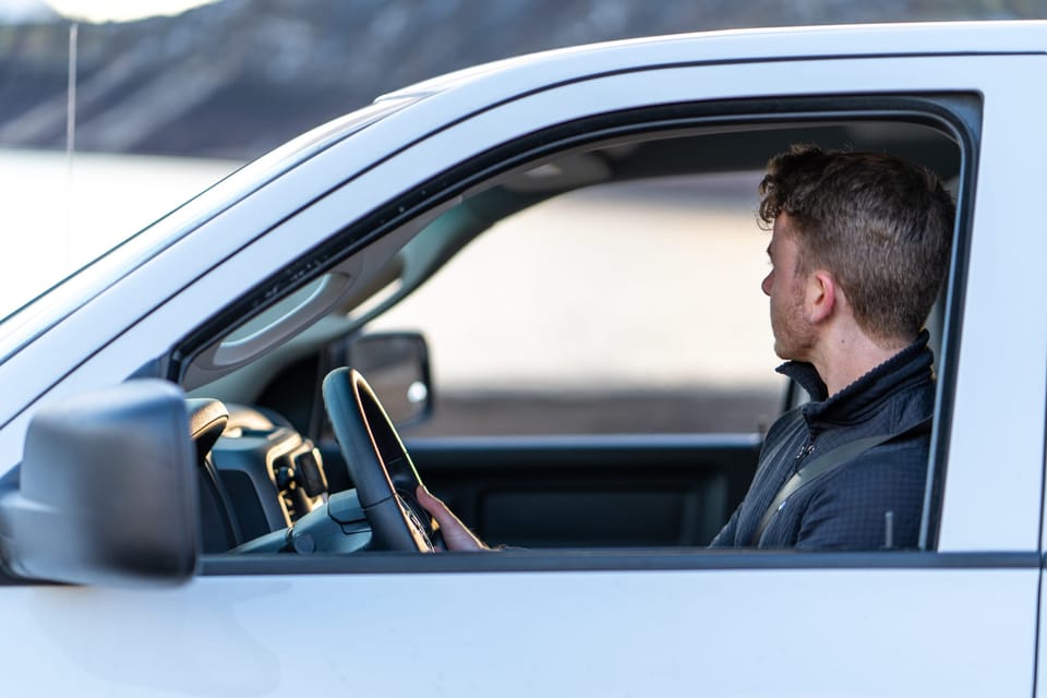 Man in the driver's seat of a white truck