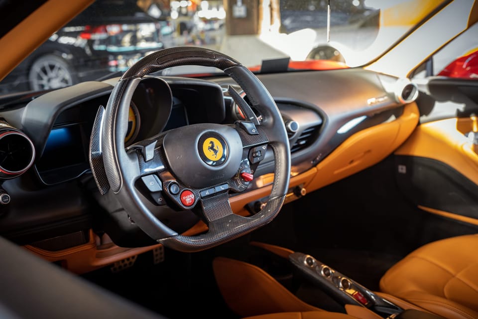 Tan leather cockpit and steering wheel of a Ferrari