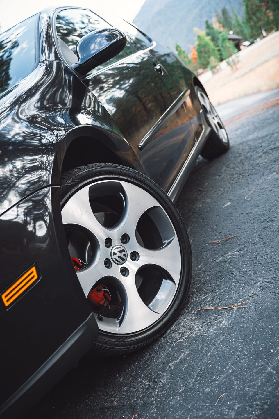 Low-angle detail of a black hatchback's wheel and fender