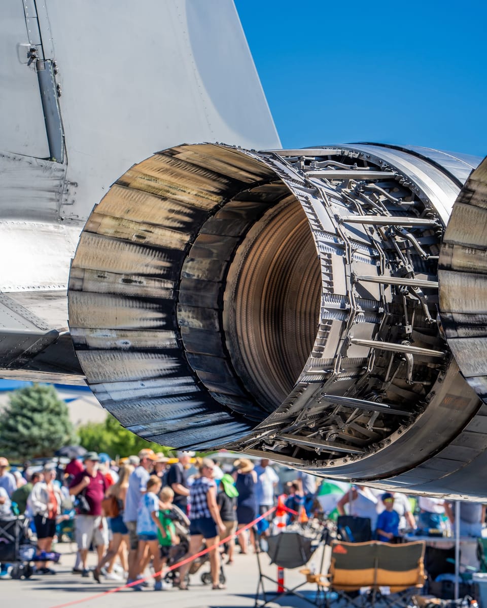 Close-up of a jet engine exhaust nozzle above an airshow crowd