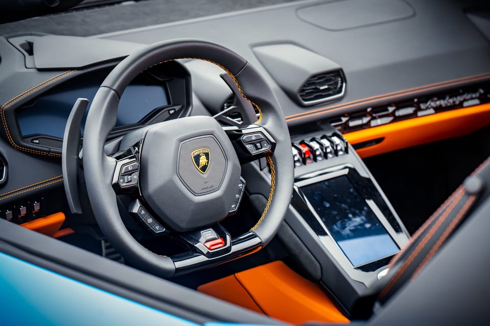 Lamborghini steering wheel and orange-trimmed cockpit