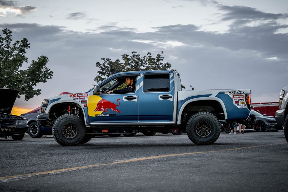 Lifted blue pickup truck at a drag strip