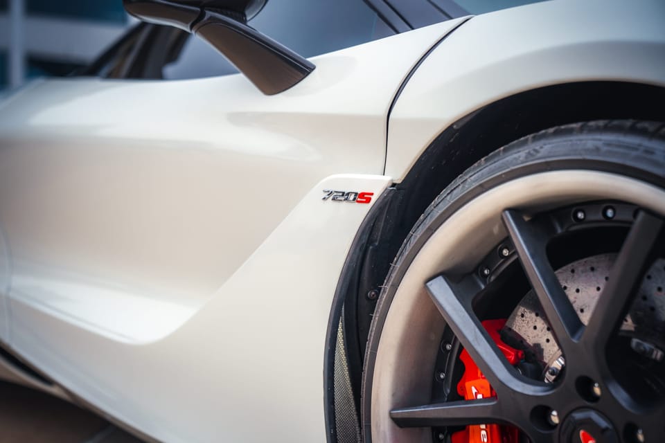 Wheel and red brake caliper of a white McLaren