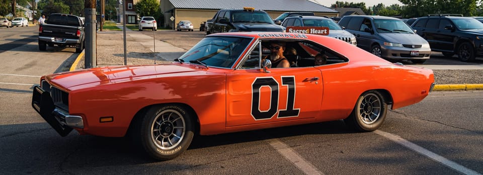 Orange classic Dodge Charger with a 01 door number at a car show