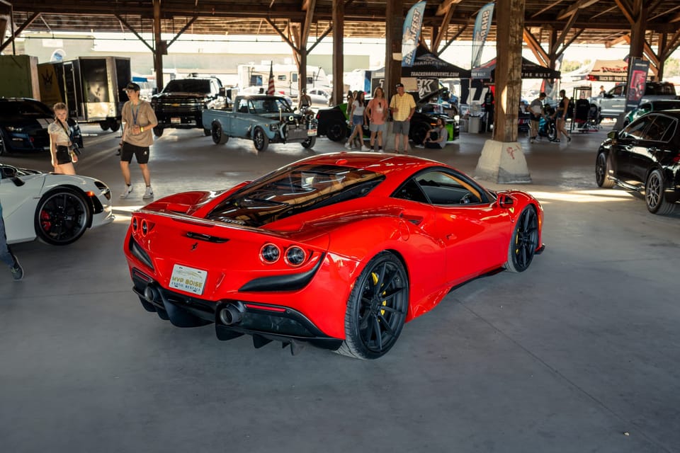 Red Ferrari under a covered car-show pavilion