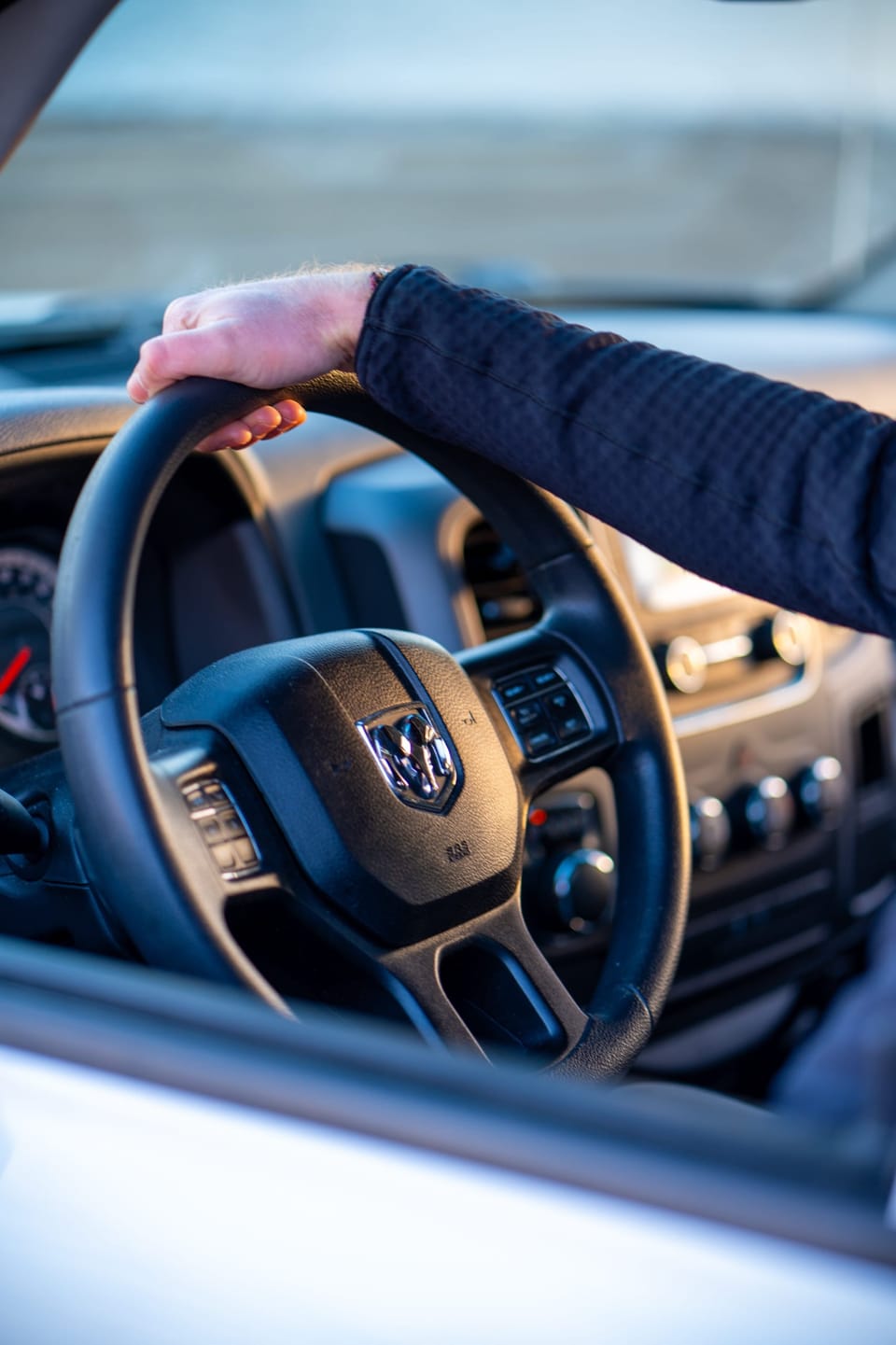 Hand on the steering wheel of a truck